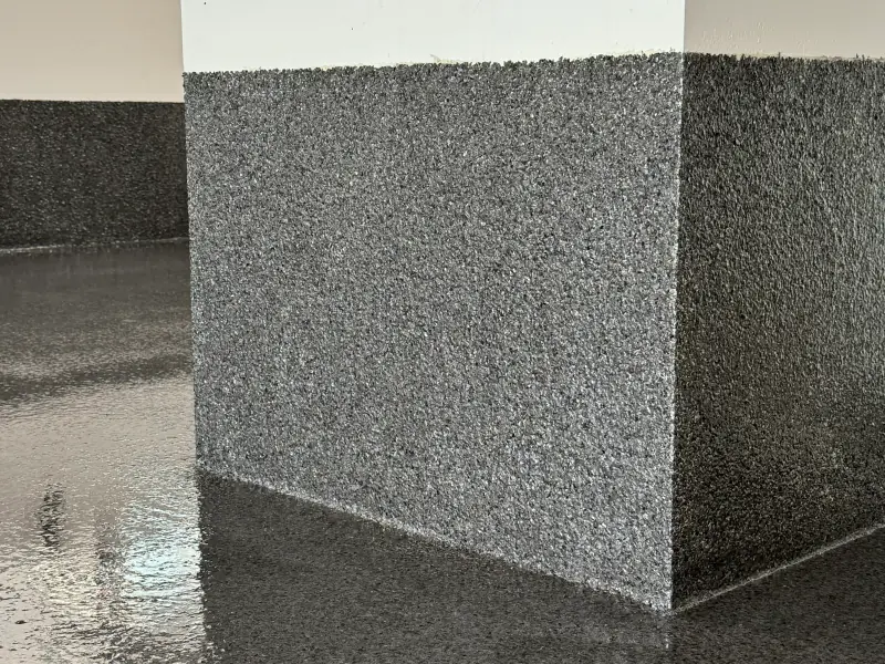 Détail d’un pilier et d’une plinthe en époxy à flocons, montés au mur