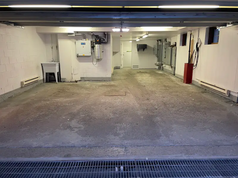 Garage double au plancher de béton brut, avant les travaux