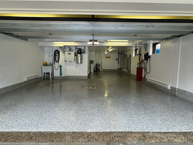 Le même garage double terminé, plancher époxy à flocons gris avec plinthe intégrée