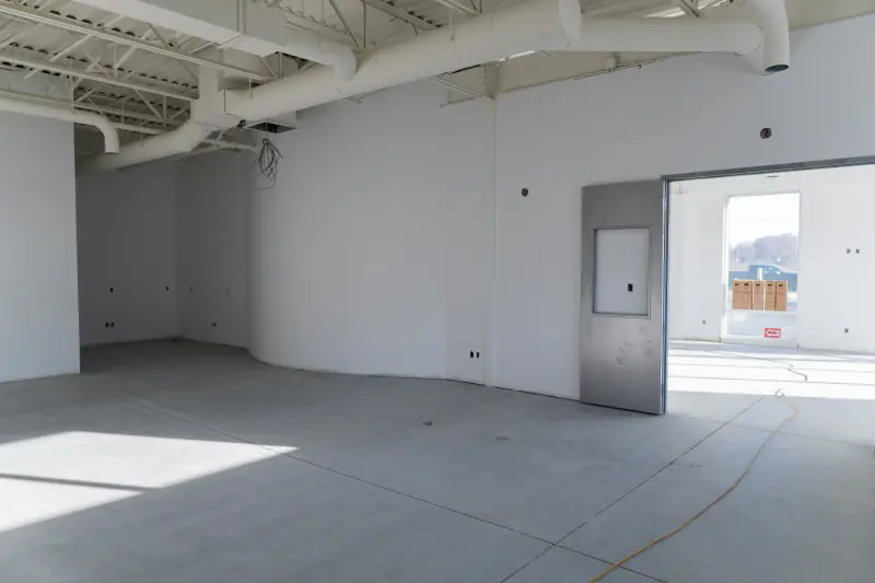 Dalle de béton nue dans un local commercial en construction, avant l’application